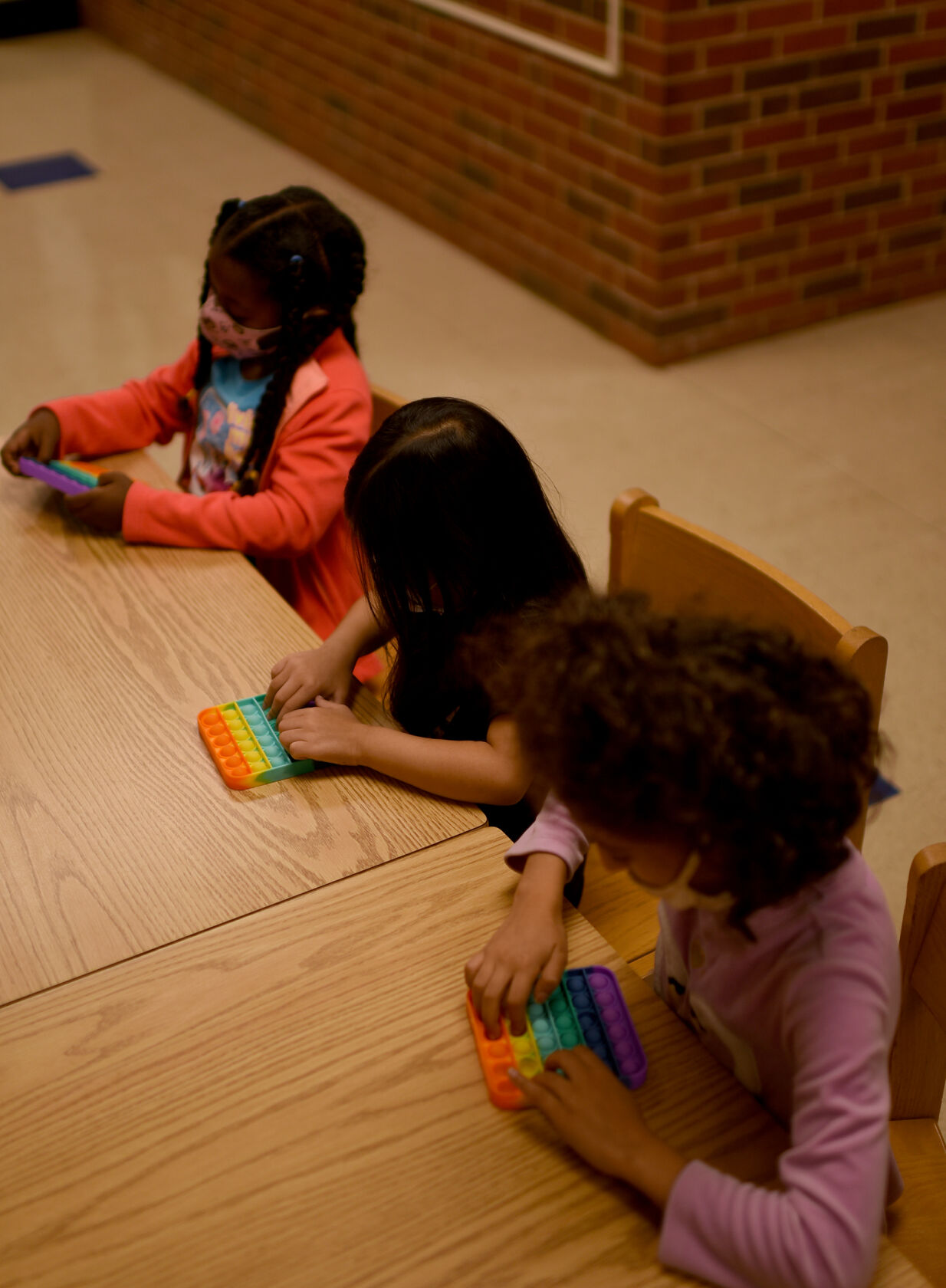 From left to right first grade students Razan Ali, Zoey Lam and Nyah Saleh pop the bubbles